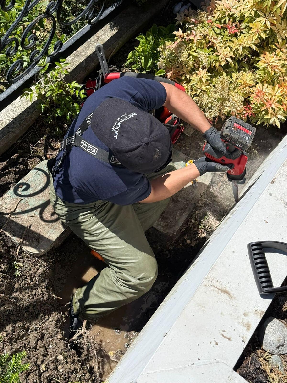 Mr. Plunger plumber working on an outdoor sewer cleanout in a Lower Mainland yard